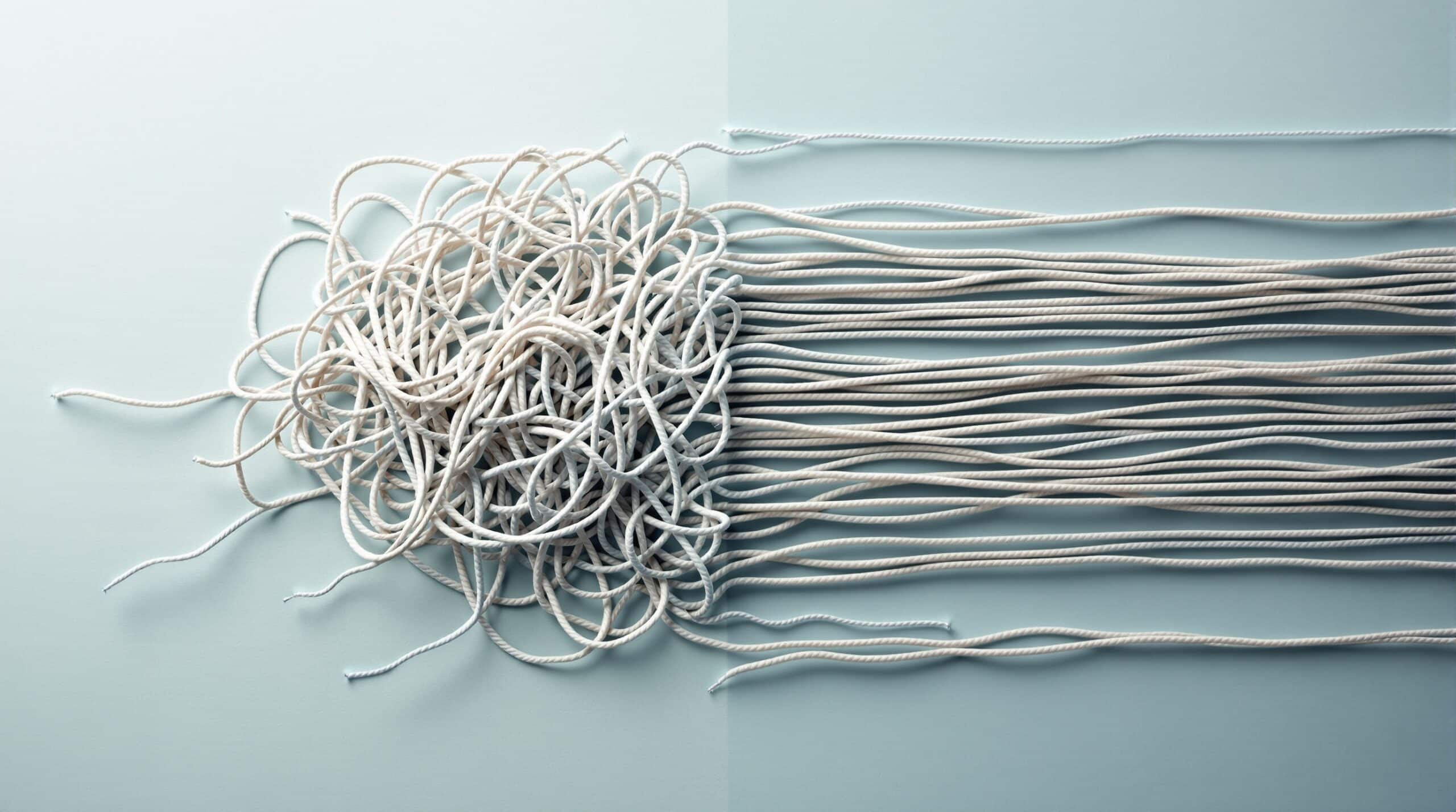 Tangled yarn gradually becoming untangled, symbolizing the CBT process of organizing confused thoughts into clarity